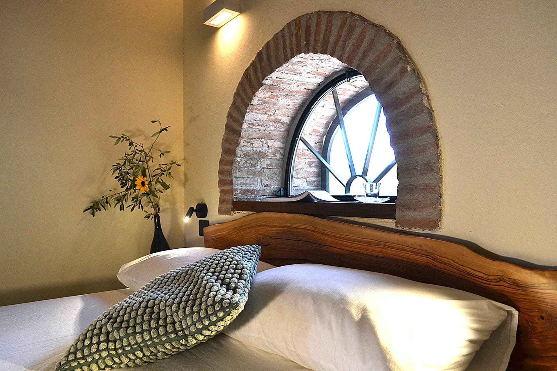 Bedroom with a brick-arched window and morning light