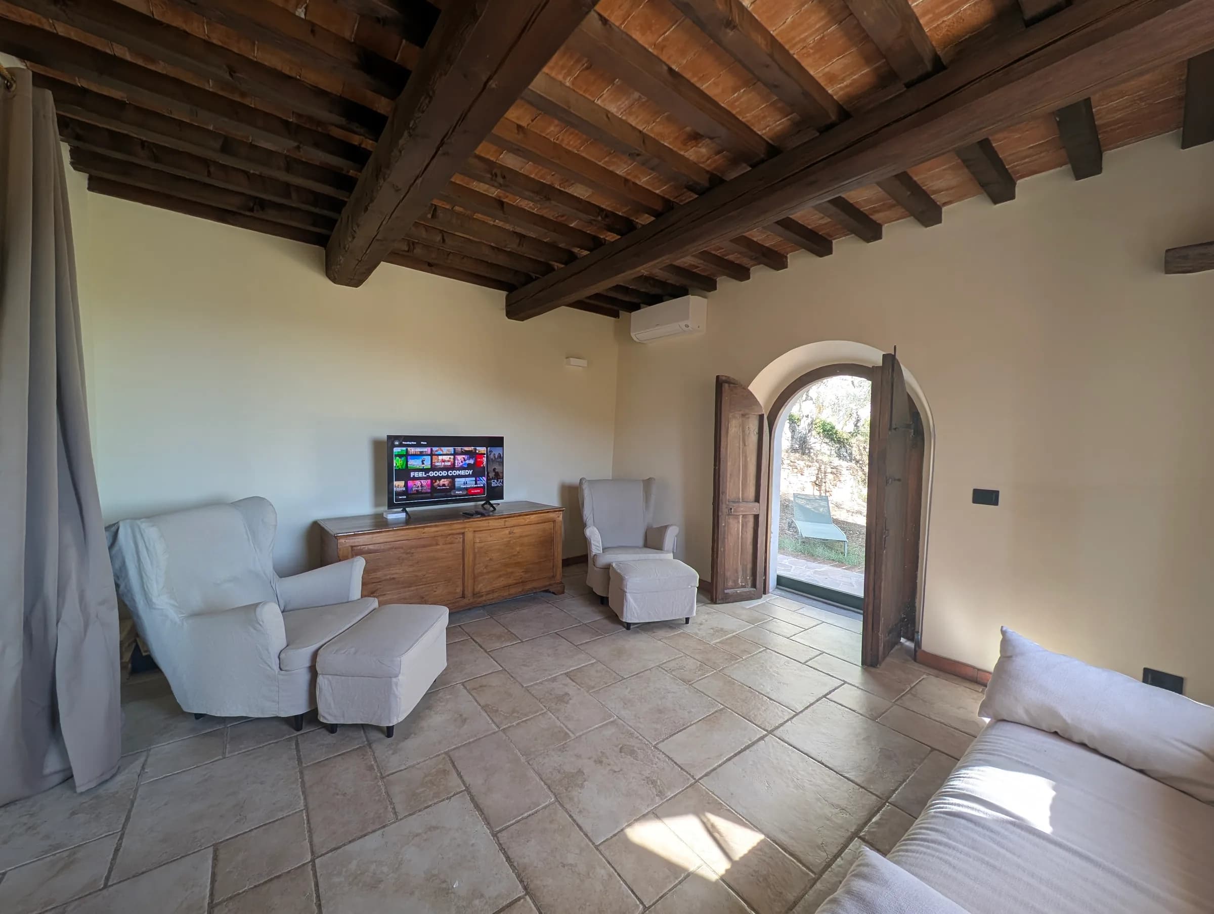 A cosy TV lounge opening through an archway to the entrance hall
